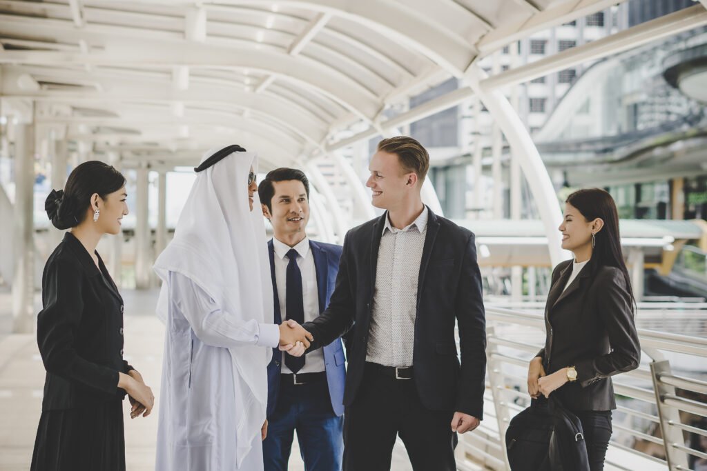 Portrait of business partners greeting one another by handshaking on the way to office.